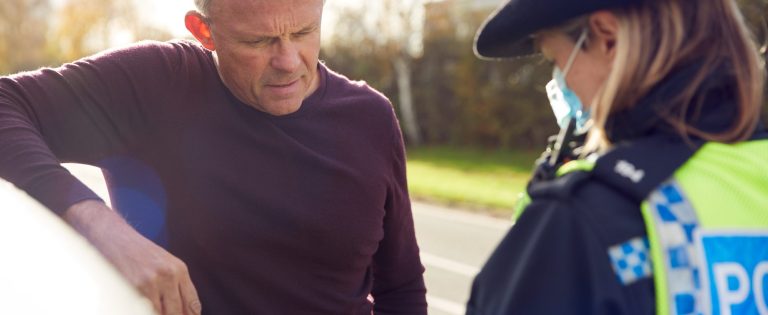 Male Driver Being Stopped By Female Traffic Police Officer For Driving Offence